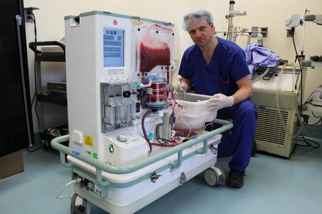 Doctor markus selzner kneeling beside the OrganOx metra®