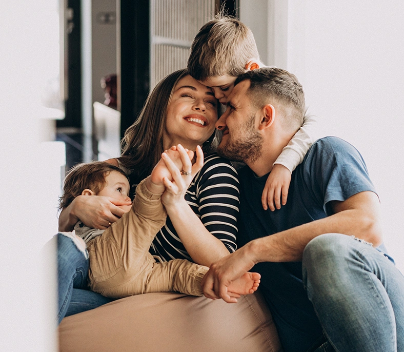 Happy family of four hugging each other