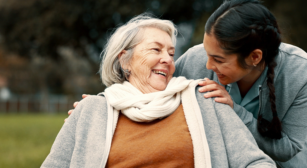 Elderly woman smiling at younger woman